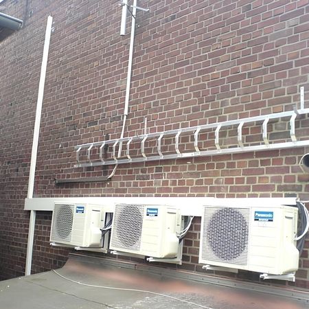 Ziegelwand mit sichtbarer Kälte- und Klimatechnik.